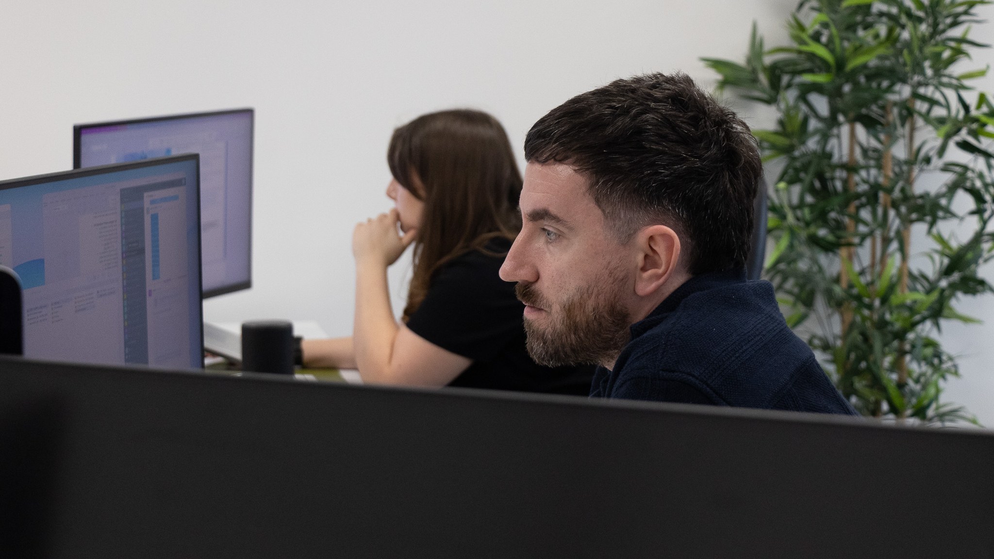Two Intimation designers concentrating at their screens in the Newcastle studio